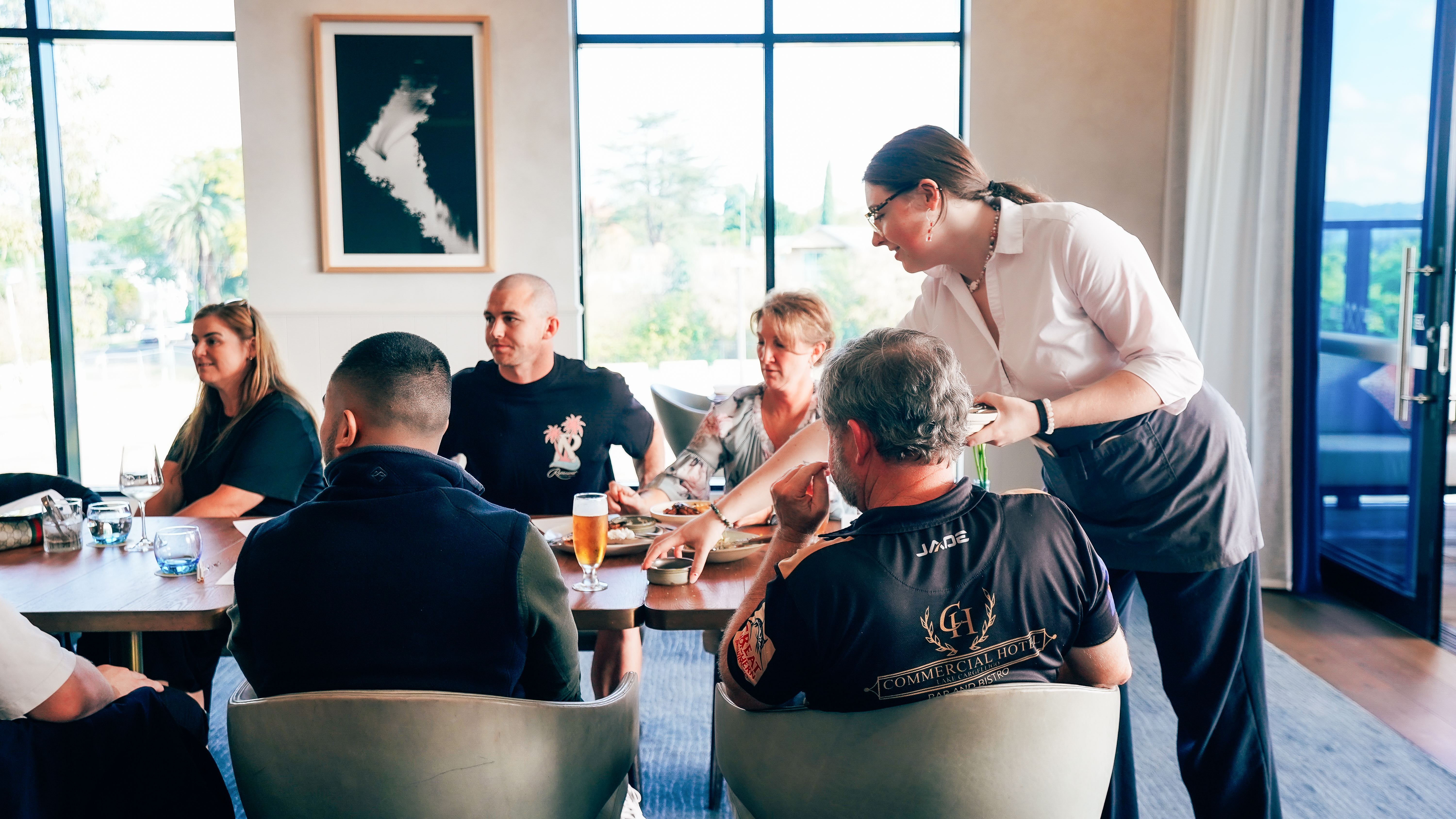 waitress serving group of people in restaurant